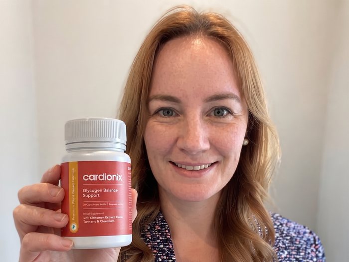 Kvinna som håller en burk Cardionix, den dagliga dosen före huvudmålet